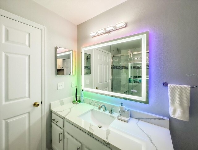 bathroom featuring vanity and a shower with door