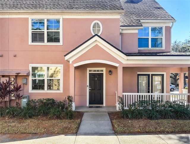 3383 Westchester Square Blvd Unit 202, Orlando, FL 32835 - view of exterior entry with a porch, stucco siding, and a shingled roof