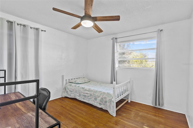 bedroom with a textured ceiling, hardwood / wood-style flooring, and ceiling fan