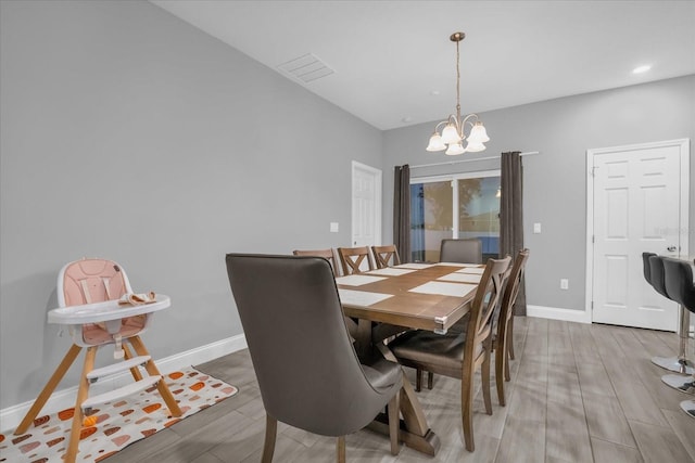 dining room with hardwood / wood-style flooring and a notable chandelier