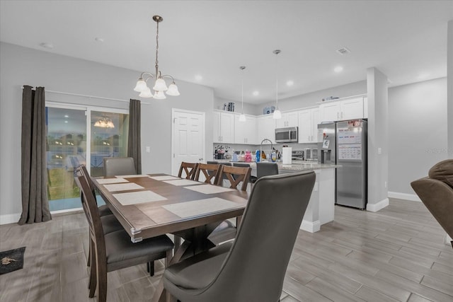 dining space with a chandelier and light wood-type flooring