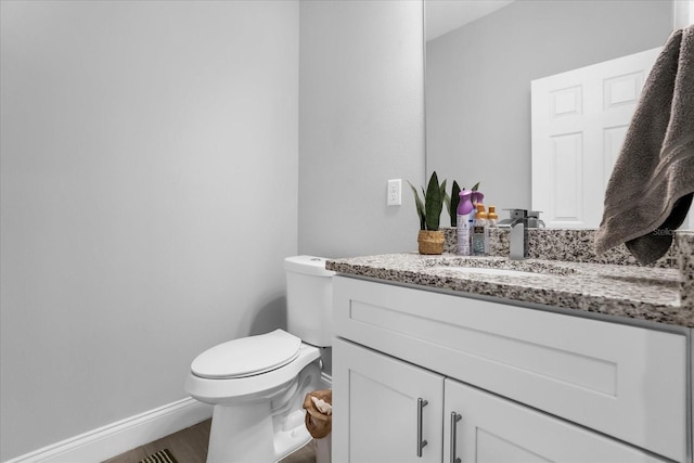 bathroom featuring hardwood / wood-style floors, vanity, and toilet