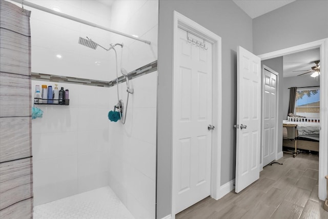 bathroom with hardwood / wood-style flooring, ceiling fan, and tiled shower