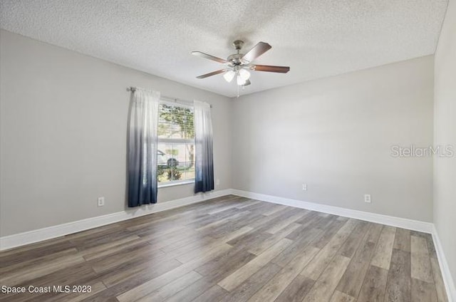 empty room with ceiling fan, hardwood / wood-style floors, and a textured ceiling