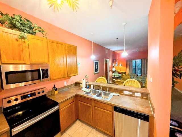 kitchen featuring hanging light fixtures, kitchen peninsula, sink, and appliances with stainless steel finishes