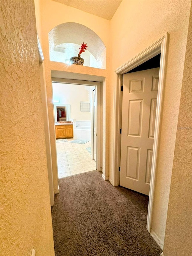 hall with carpet and a textured ceiling