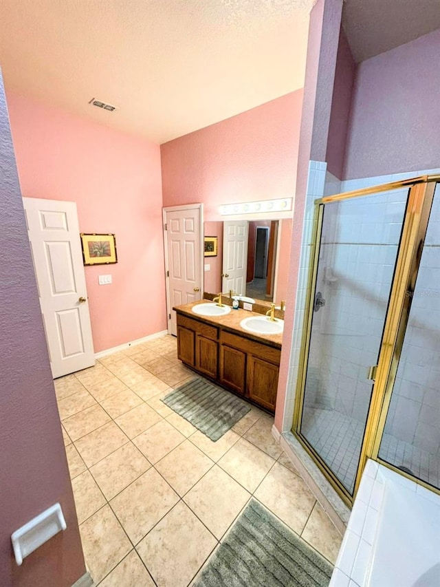 bathroom with tile patterned flooring, vanity, and a shower with door