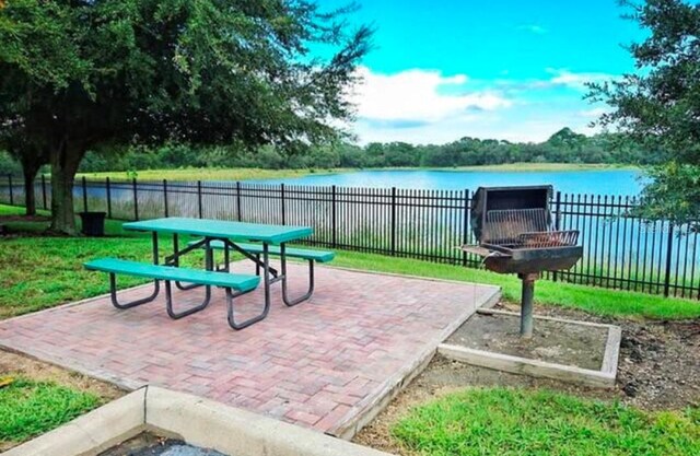 view of patio with a fire pit and a water view