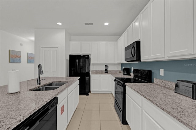 kitchen with light stone countertops, sink, white cabinetry, and black appliances