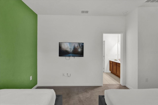 bedroom with light colored carpet and connected bathroom