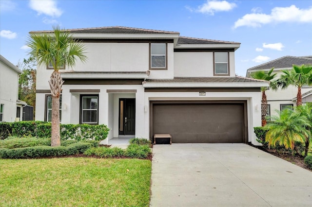 view of front of property featuring stucco siding, a front lawn, concrete driveway, and a garage