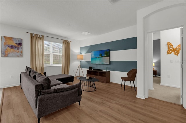 living area featuring baseboards and wood finished floors