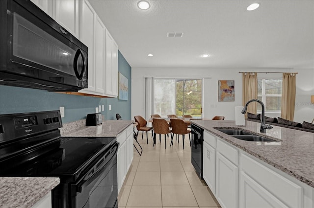 kitchen with visible vents, black appliances, light tile patterned floors, white cabinetry, and a sink