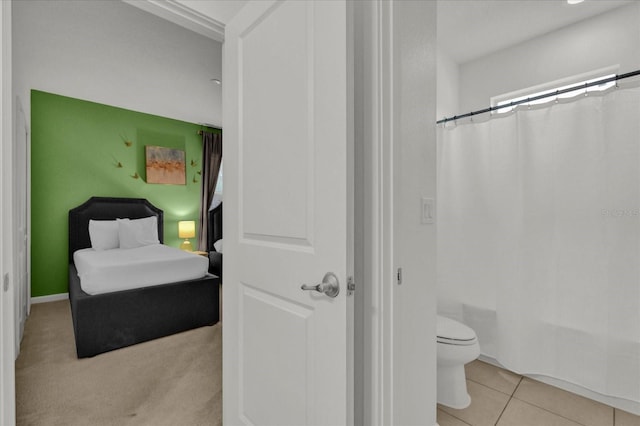 bathroom with tile patterned flooring, toilet, and shower / bath combo with shower curtain