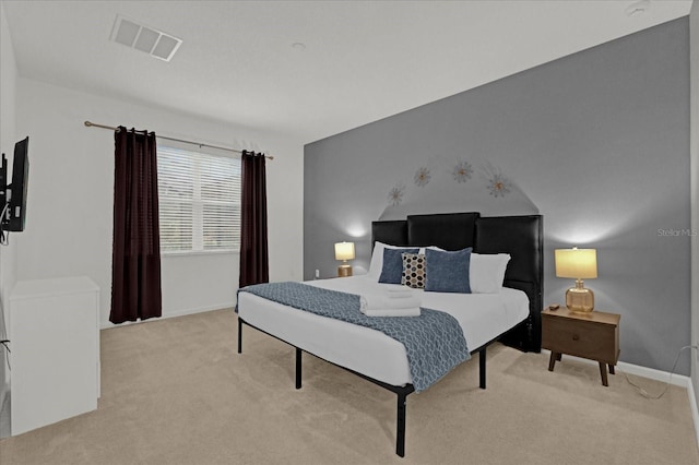 bedroom with light colored carpet, visible vents, and baseboards