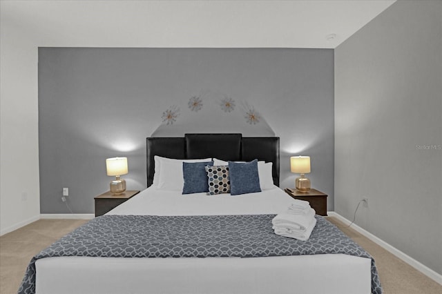 bedroom with baseboards and light carpet