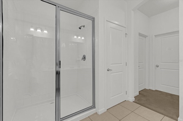 full bathroom with a stall shower and tile patterned flooring
