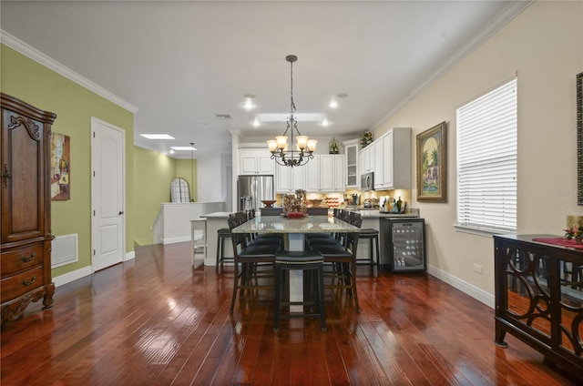 dining area with dark hardwood / wood-style floors, ornamental molding, beverage cooler, and a chandelier