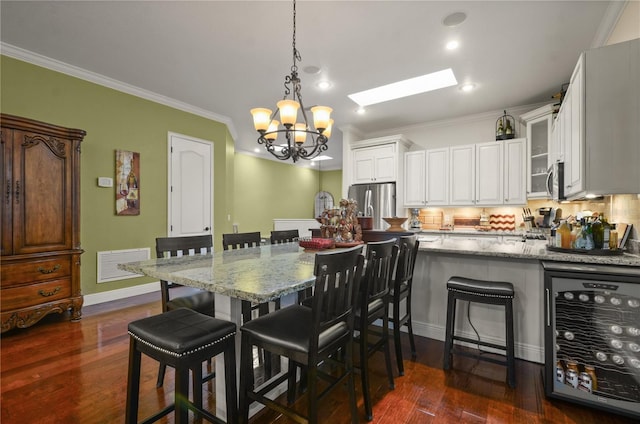 dining room featuring a chandelier, dark hardwood / wood-style floors, wine cooler, and ornamental molding