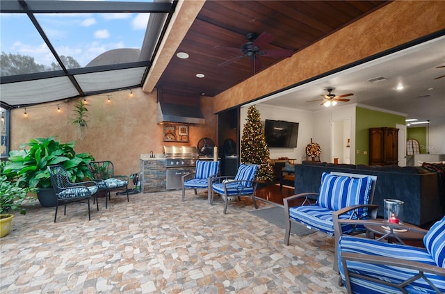 view of patio featuring glass enclosure, area for grilling, ceiling fan, and a grill