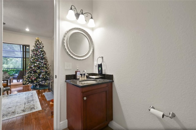 bathroom featuring vanity, hardwood / wood-style flooring, and crown molding