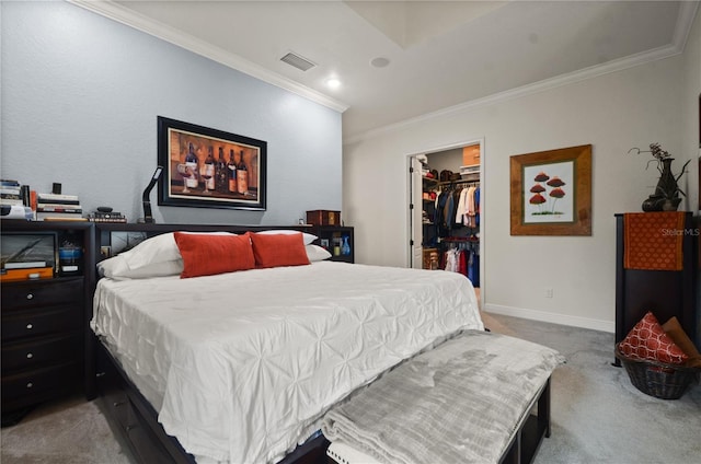 carpeted bedroom with a spacious closet, crown molding, and a closet