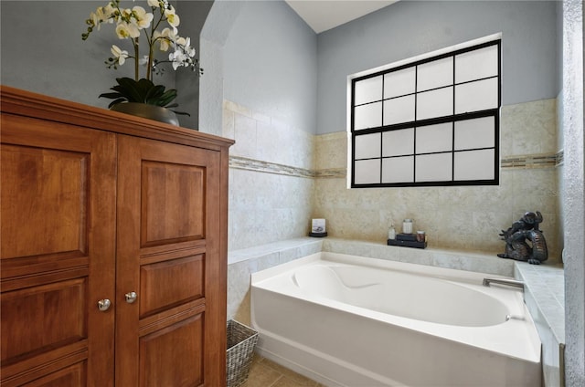 bathroom with tile patterned floors, a bathtub, and tile walls