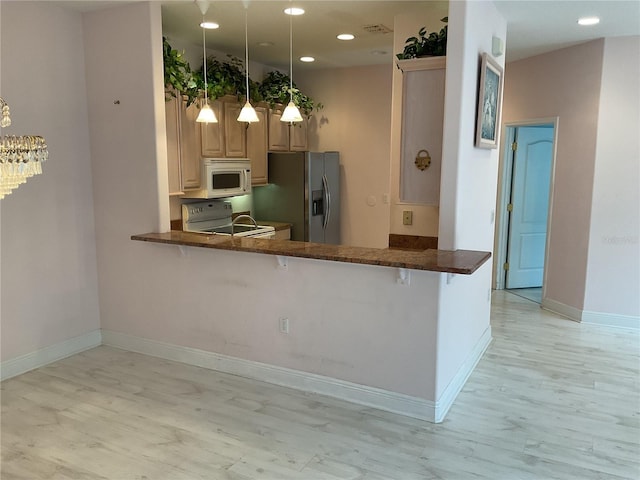 kitchen featuring stainless steel fridge, kitchen peninsula, hanging light fixtures, and electric range oven