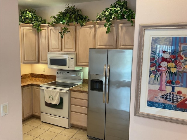 kitchen with light tile patterned flooring, white appliances, and light brown cabinets