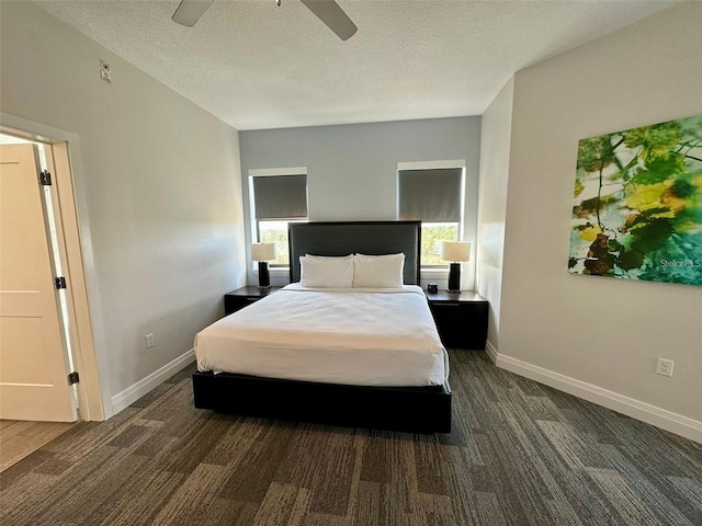 bedroom with a textured ceiling, ceiling fan, and dark wood-type flooring