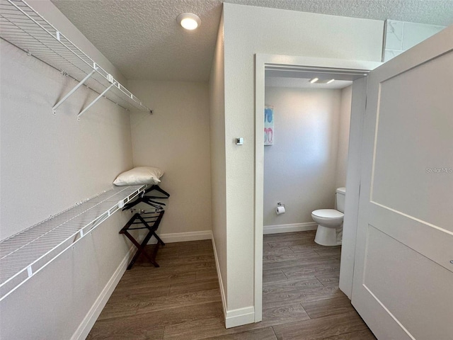 bathroom featuring hardwood / wood-style floors, toilet, and a textured ceiling