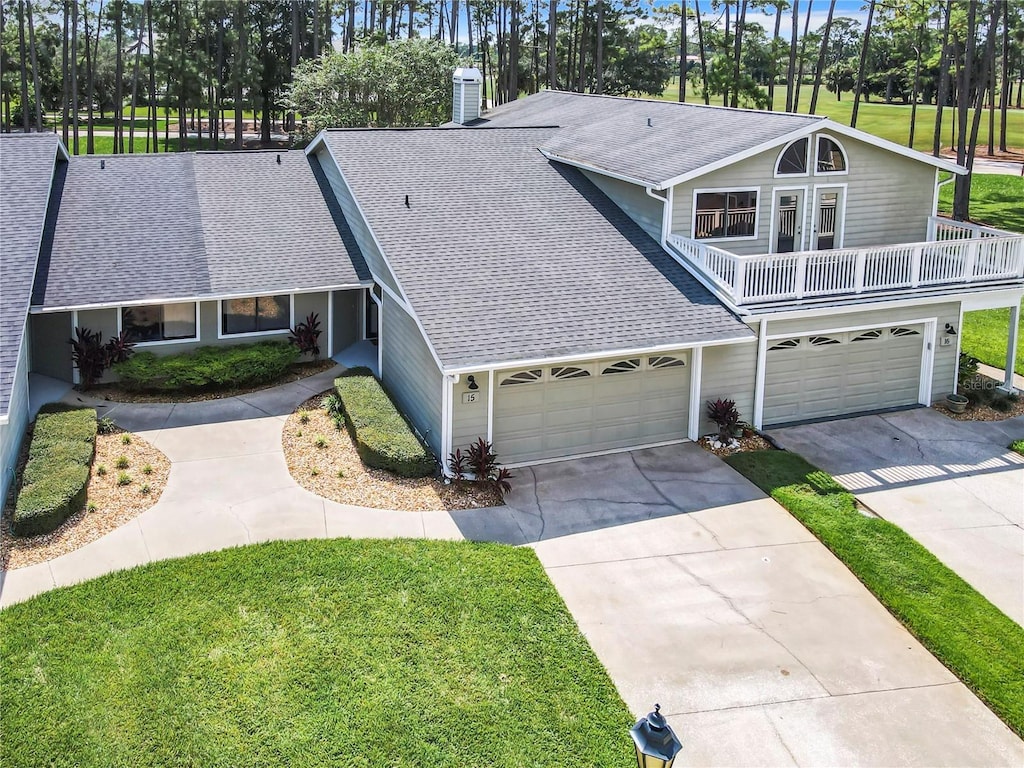 view of front of home with a balcony, a front lawn, and a garage