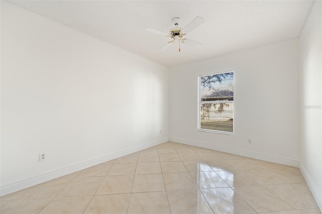 tiled spare room with a textured ceiling and ceiling fan