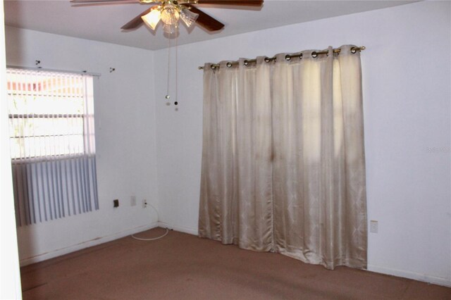 empty room with ceiling fan and baseboards