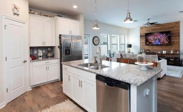 kitchen featuring appliances with stainless steel finishes, sink, pendant lighting, white cabinetry, and an island with sink