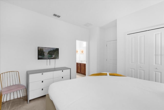 carpeted bedroom featuring ensuite bathroom and a closet