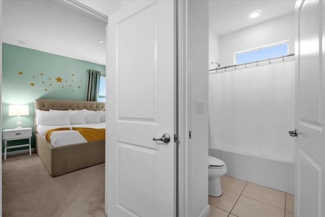 bathroom featuring tile patterned flooring, toilet, and shower / bath combo with shower curtain