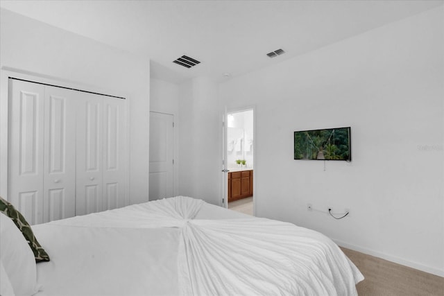 carpeted bedroom featuring connected bathroom and a closet