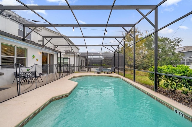 view of swimming pool with glass enclosure and a patio area