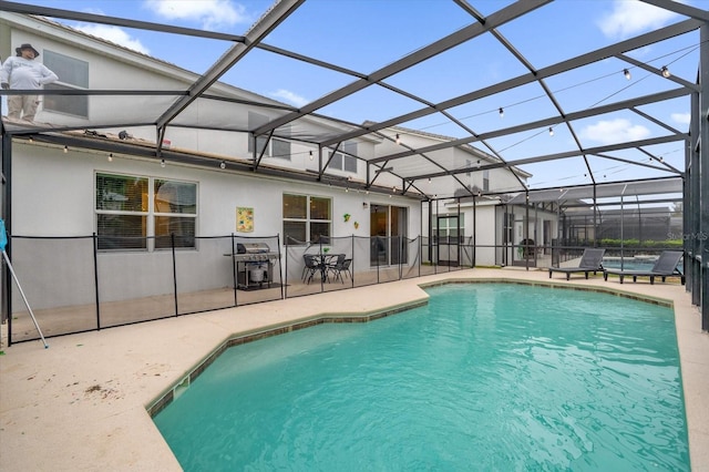 view of pool featuring glass enclosure and a patio area