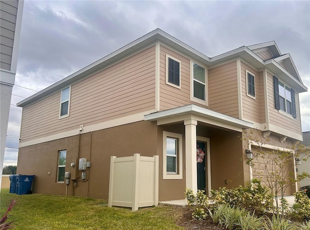 view of home's exterior with a garage and a lawn