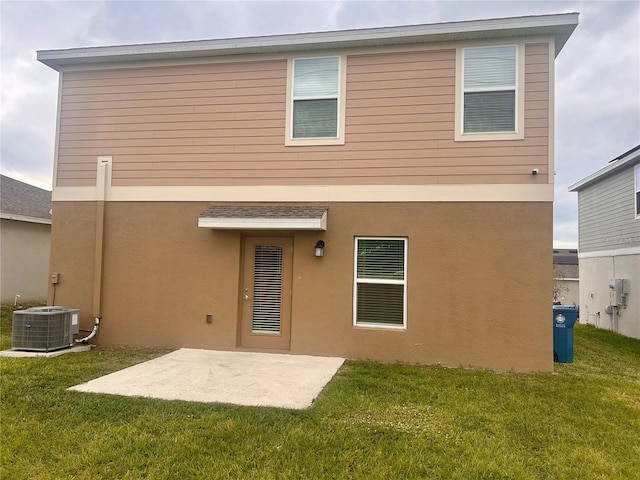 rear view of house featuring a lawn, central air condition unit, and a patio