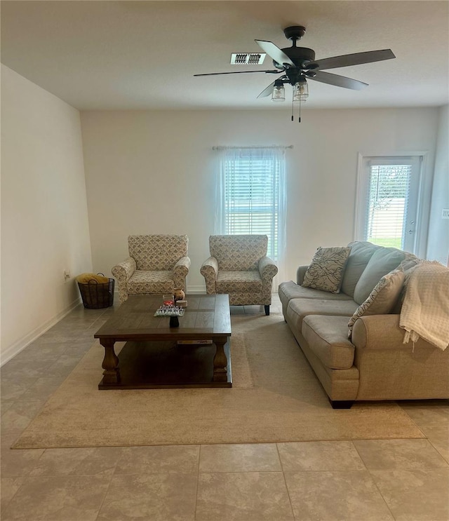 tiled living room with ceiling fan and a healthy amount of sunlight