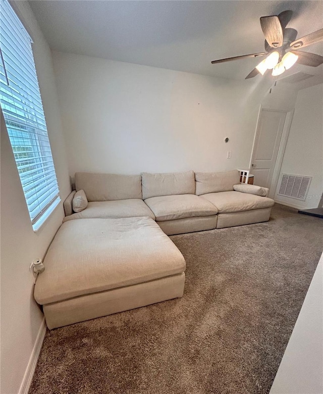 living room featuring ceiling fan, carpet, and a healthy amount of sunlight