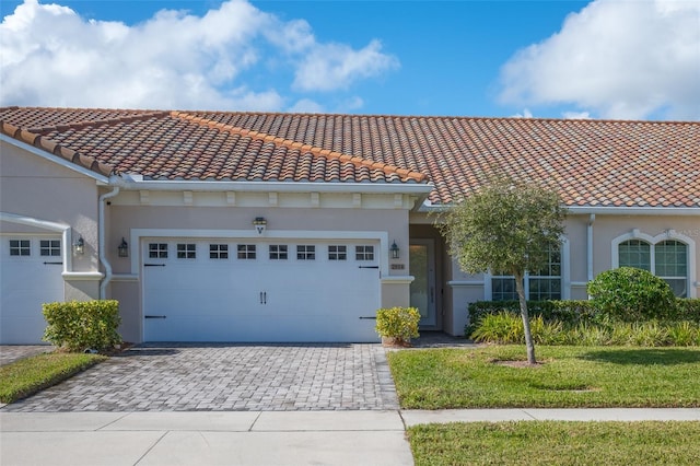 mediterranean / spanish house featuring a garage and a front yard