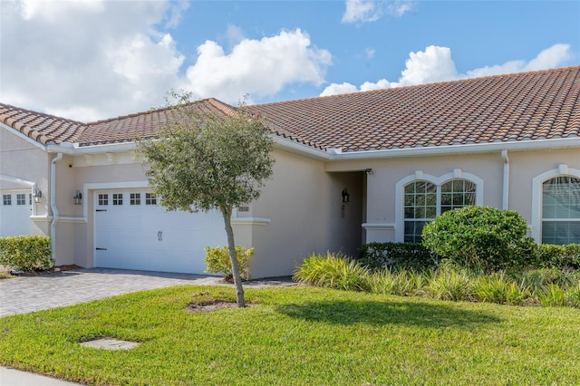 mediterranean / spanish house with a front lawn and a garage