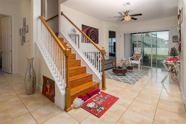 stairs featuring ceiling fan and tile patterned flooring