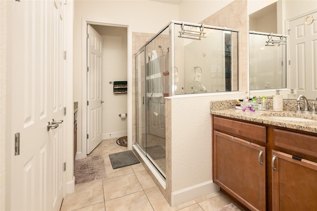 bathroom featuring tile patterned flooring, vanity, and a shower with door