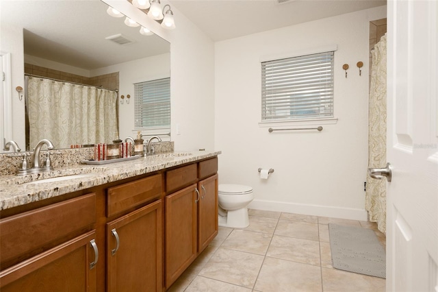 bathroom with tile patterned flooring, vanity, and toilet