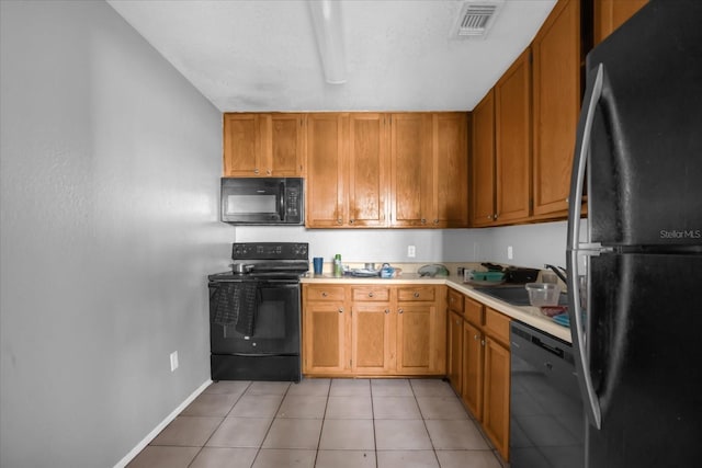 kitchen with sink, light tile patterned flooring, and black appliances